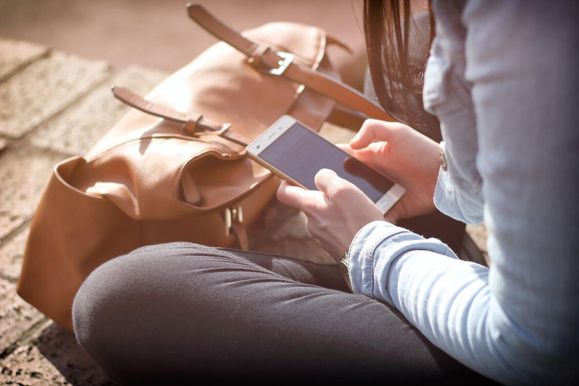 Man looking at his vacation rental website or small business website on his phone and liking the transparent pricing he pays to his web designer.